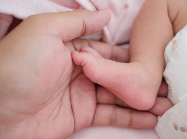 手のひらにある赤ちゃんの足のカットされた画像