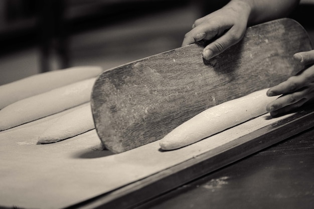 cropped image of baker making bread at bakery
