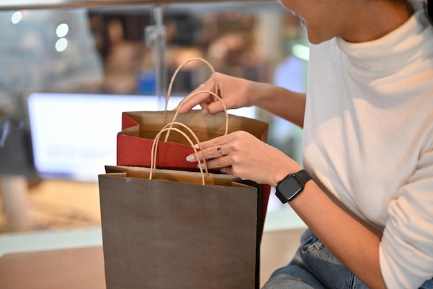 Cropped image of a beautiful Asian woman opening her shopping bags