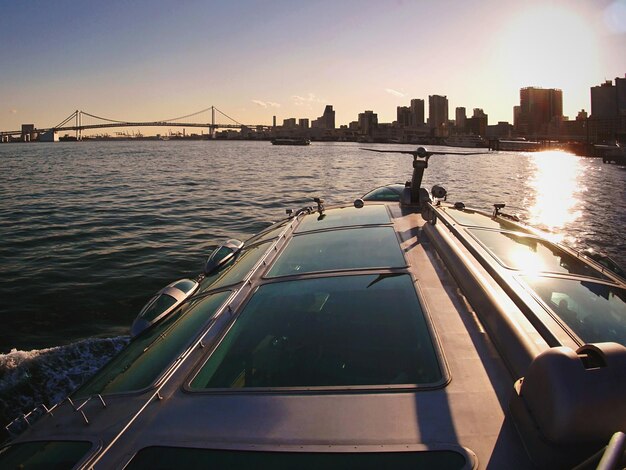 Cropped image of boat in river against sky on sunny day