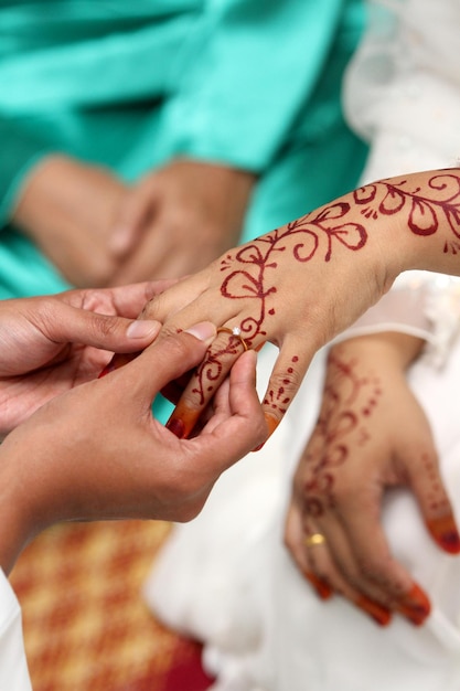 Photo cropped image of bridegroom wearing wedding ring to bride