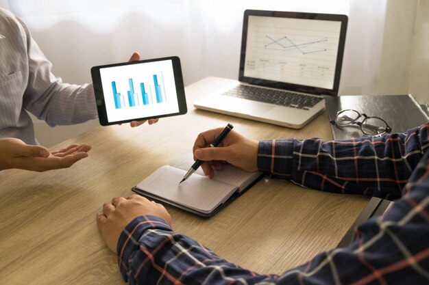 Photo cropped image of business people discussing over digital tablet at desk in office