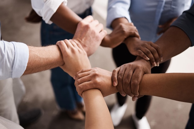 Photo cropped image of business people stacking hands