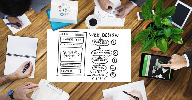 cropped image of business people working by web design page