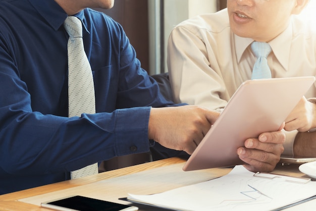 Cropped image businessman sitting at the table with cup of coffee