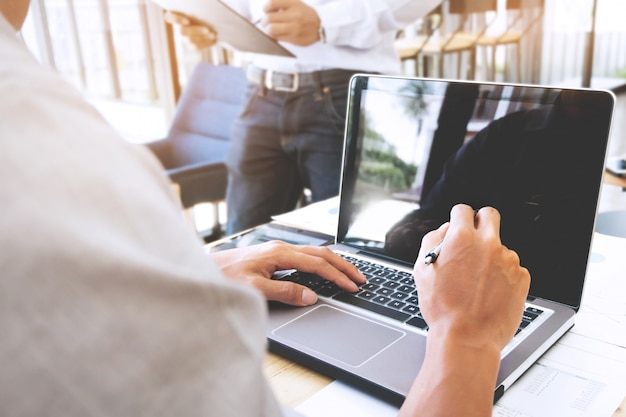 Foto immagine ritagliata di uomo d'affari che lavora con il computer portatile in un ufficio