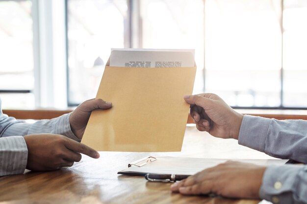 Photo cropped image of businessmen holding document at desk in office