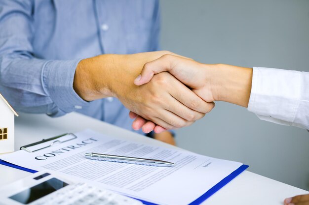 Cropped image of businesswoman shaking hands with male colleague in office