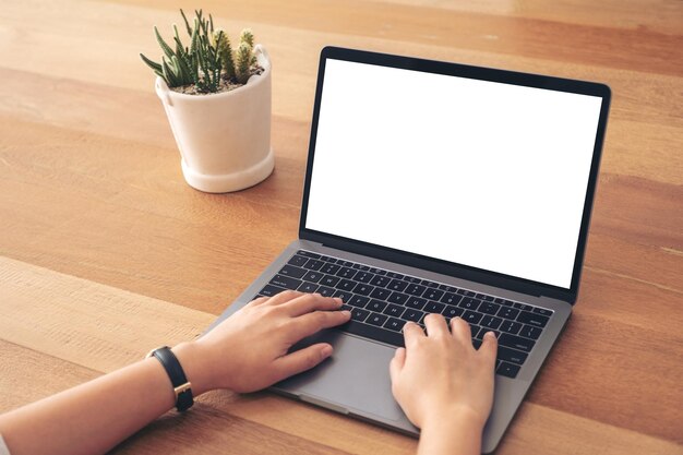 Photo cropped image of businesswoman using laptop on wooden table in office