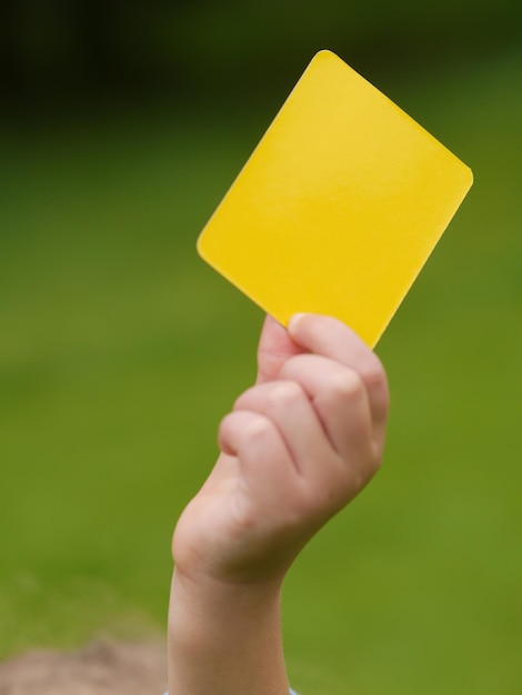 Foto immagine ritagliata di un bambino con un cartellino giallo durante una partita di calcio