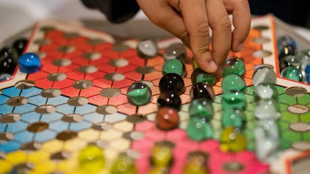 Photo cropped image of child playing with marbles on colorful container