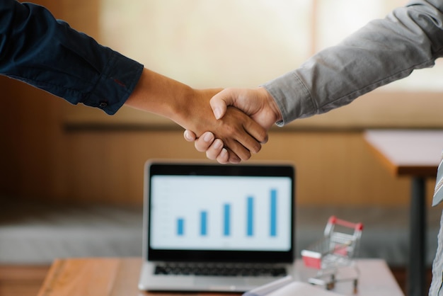 Cropped image of colleagues shaking hands in office