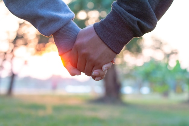 Photo cropped image of couple holding hands in park