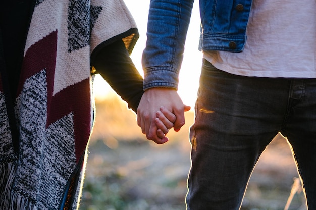 Photo cropped image of couple holding hands on sunny day