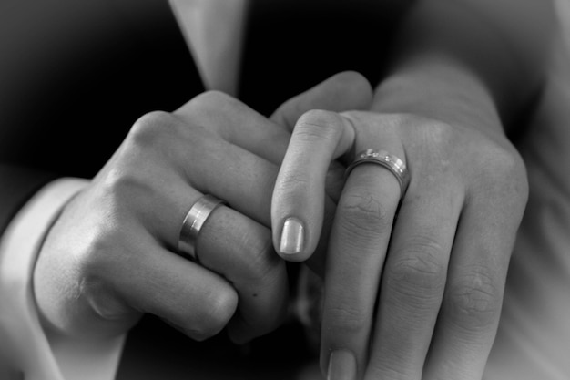 Photo cropped image of couple wearing finger rings and holding hands