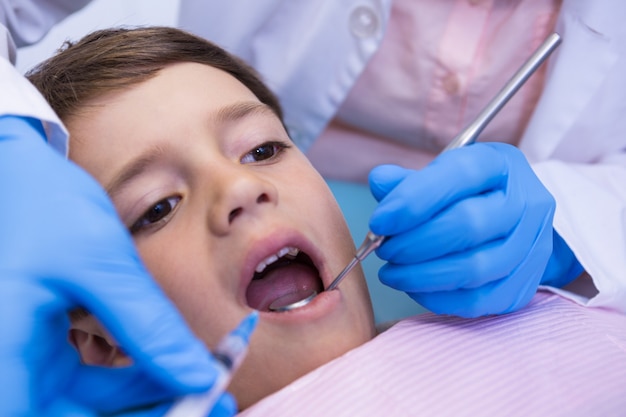 Cropped image of dentist examining boy