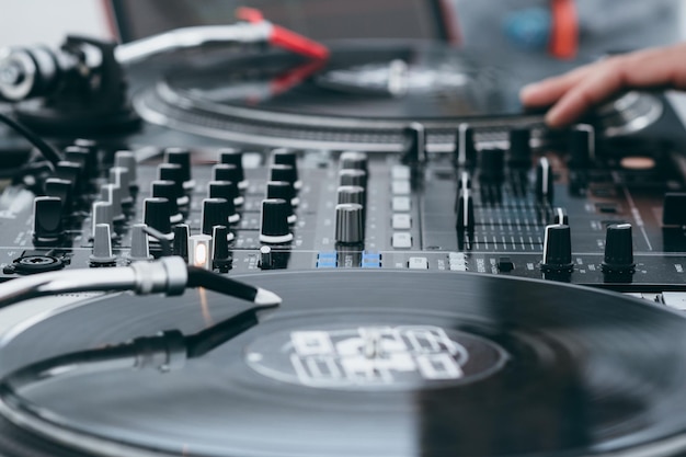 ターンテーブルで音楽をミックスするDJのクロップされた画像