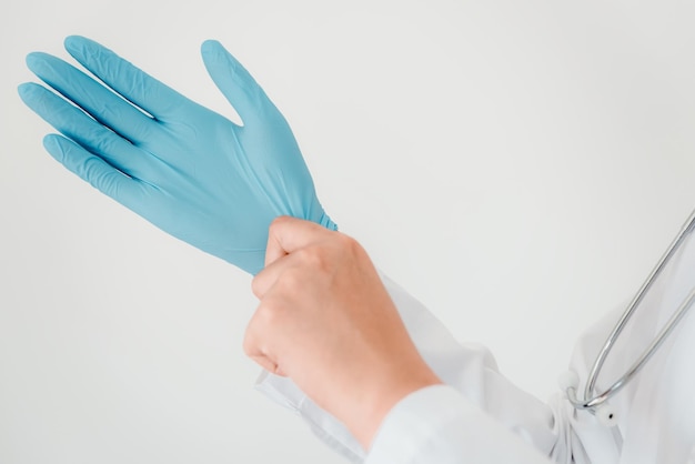 Photo cropped image of doctor wearing surgical gloves against white background