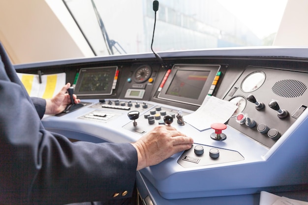 cropped image of driver sitting in train control room