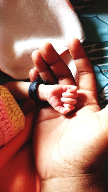 Photo cropped image of father with newborn child on bed at home