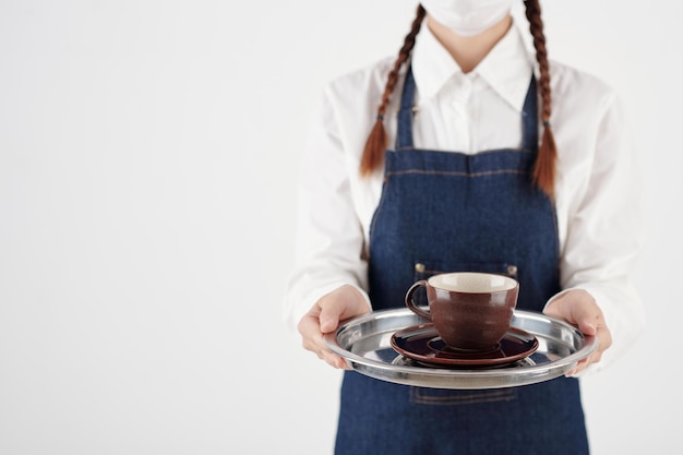 Photo cropped image of female barista holding tray with cup of coffee or tea