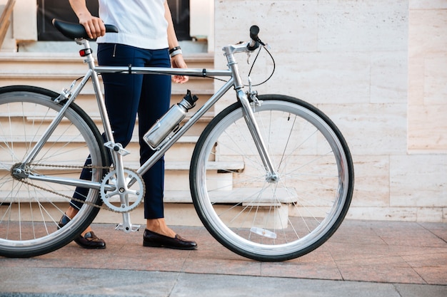 路上で自転車を持って立っている女性のバイカーのトリミングされた画像