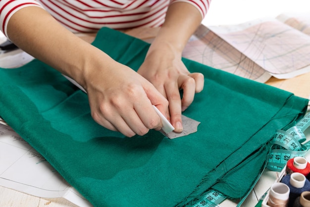 바느질 패턴을 만드는 여성 손의 자른 이미지, 작업 배경 위에 격리된 양복 바느질