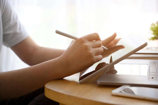 현대적인 사무실 책상 작업 공간에서 디지털 태블릿 터치패드를 사용하여 자른 이미지 여성 손