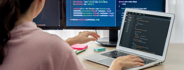 Cropped image of female web developer coding on laptop while computer displayed program and software code at modern office Close up businesswoman hand focus on analysis data Burgeoning