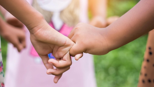 Photo cropped image of friends holding hands outdoors