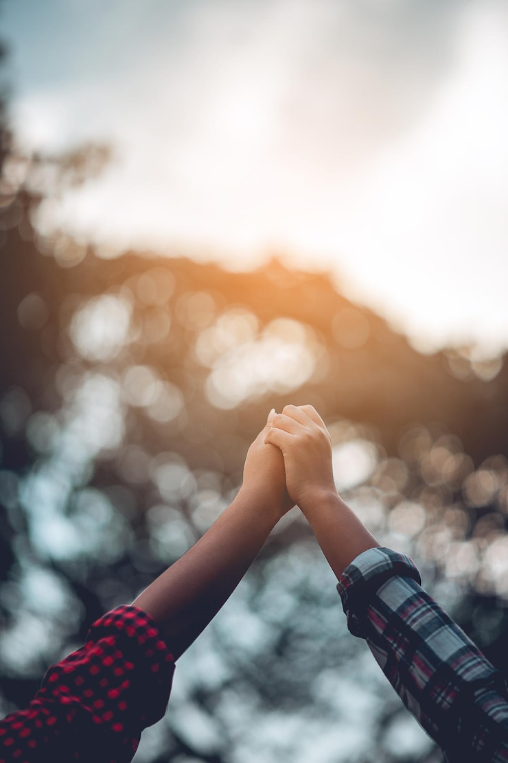 Photo cropped image of friends holding hands in park