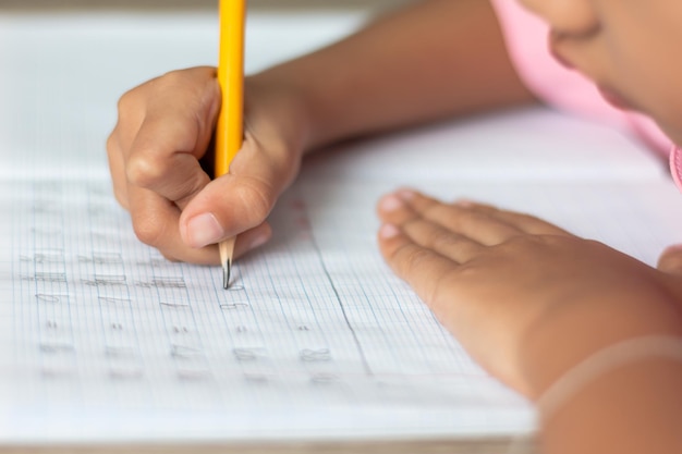 Photo cropped image of girl writing in book