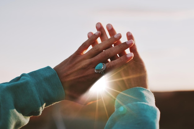 Photo cropped image of hand against sunset