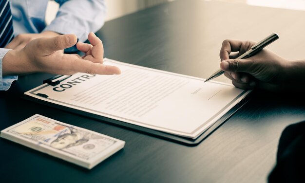 Photo cropped image of hand holding book with text on table