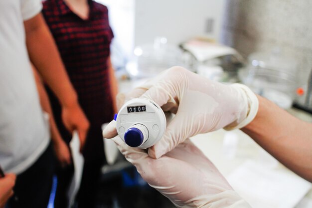 Photo cropped image of hand holding burette in laboratory