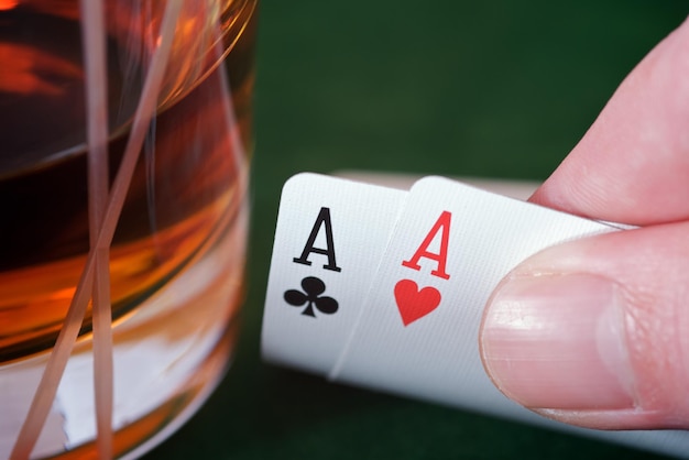 Photo cropped image of hand holding cards by drink on table