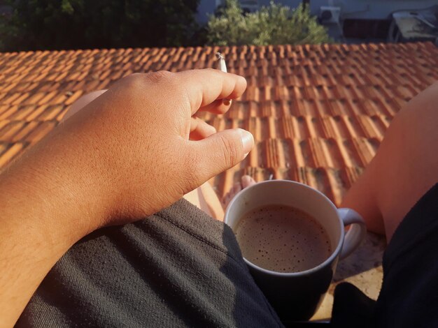 Foto immagine ritagliata di una mano che tiene una tazza di caffè