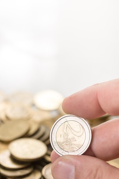 Cropped image of hand holding coin against white background