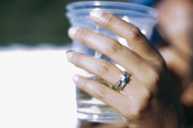 Foto immagine ritagliata di una mano che tiene un bicchiere da bere