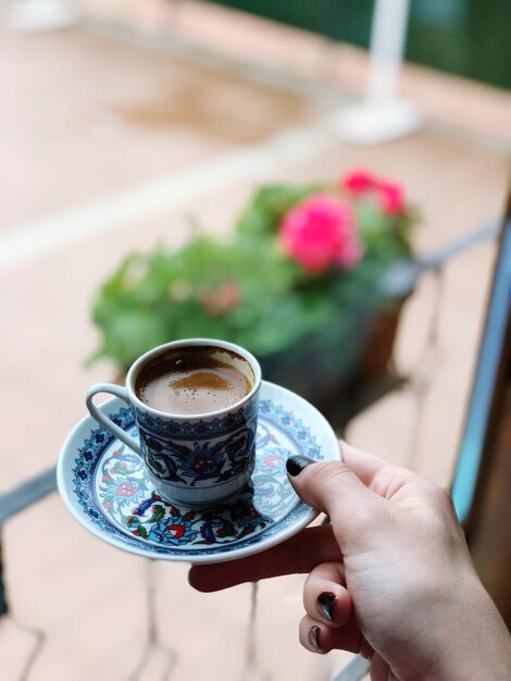 Photo cropped image of hand holding espresso cup