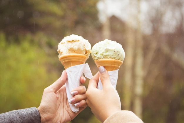 Photo cropped image of hand holding ice cream cone