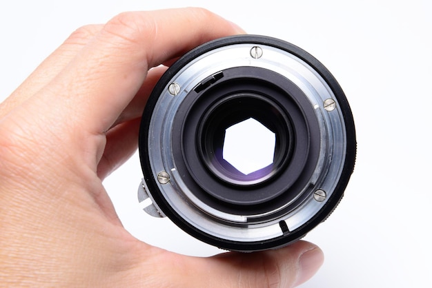 Cropped image of hand holding lens against white background