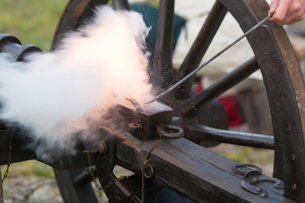 Foto immagine ritagliata di una mano che tiene una bacchetta di metallo sul fumo emesso dal cannone