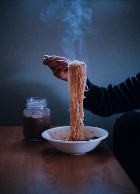 Foto immagine ritagliata di una mano che tiene i tagliatelle