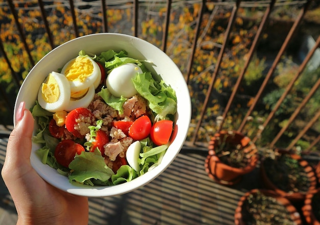 cropped image of hand holding salad in bowl