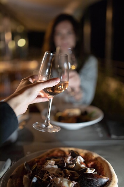 Cropped image of hand holding wineglass in restaurant
