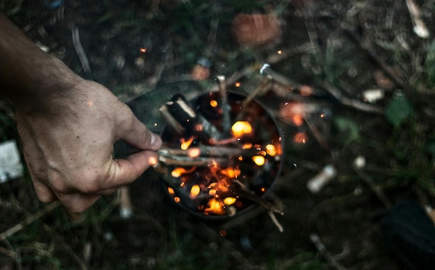 Photo cropped image of hand holding wood on fire