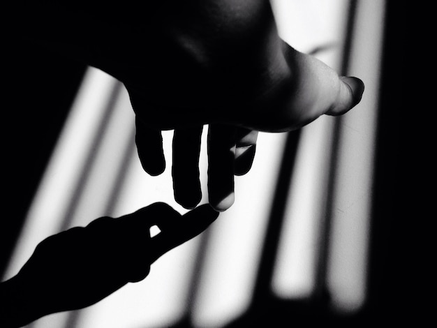 Cropped image of hand making shadow on wall