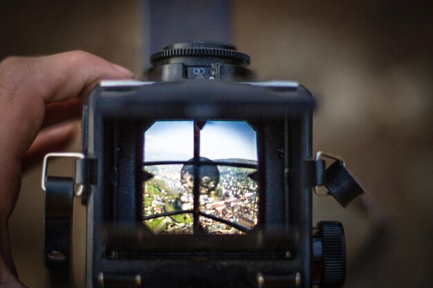 Photo cropped image of hand photographing through camera