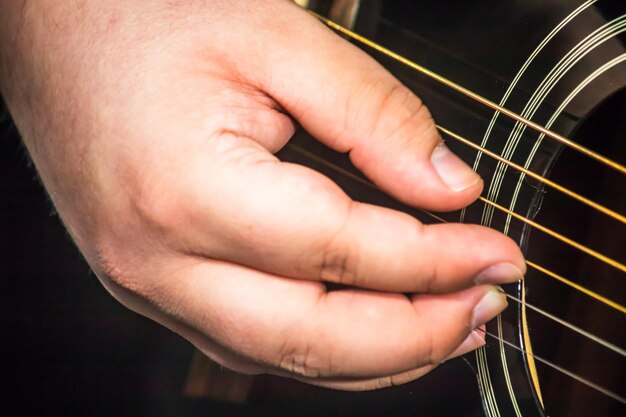 Foto immagine ritagliata di una mano che suona la chitarra